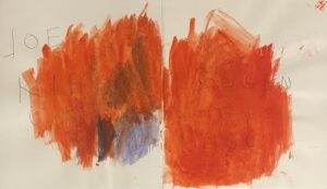 Zwei große, unregelmäßige Farbflächen in Orange und Rot mit einigen blauen und braunen Stellen, darüber handschriftlicher Text 'JOEL' und weitere schwer lesbare Buchstaben.